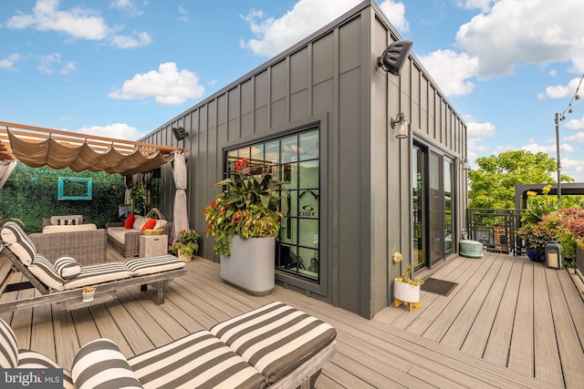 wooden deck with an outdoor living space and a pergola