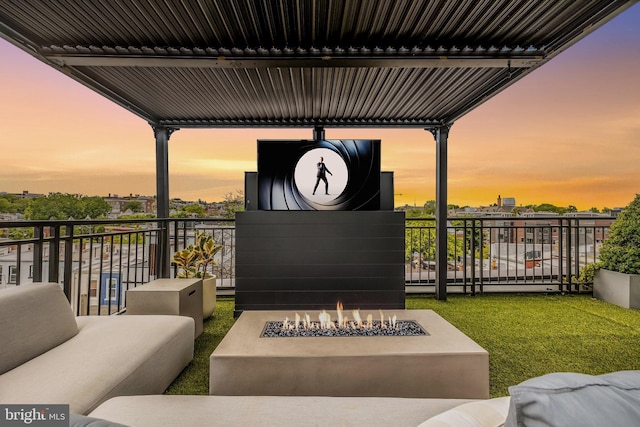 view of patio with an outdoor living space with a fire pit and a balcony