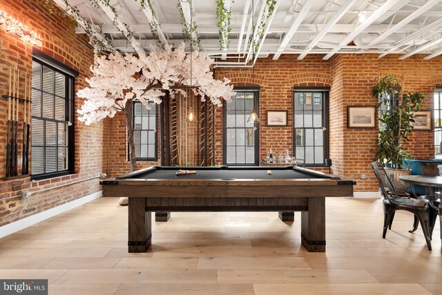 game room with billiards, brick wall, a healthy amount of sunlight, and light hardwood / wood-style floors