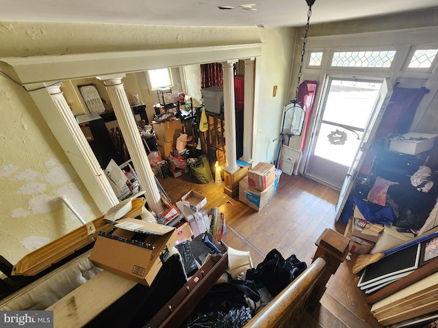 living room featuring hardwood / wood-style flooring, vaulted ceiling, and decorative columns