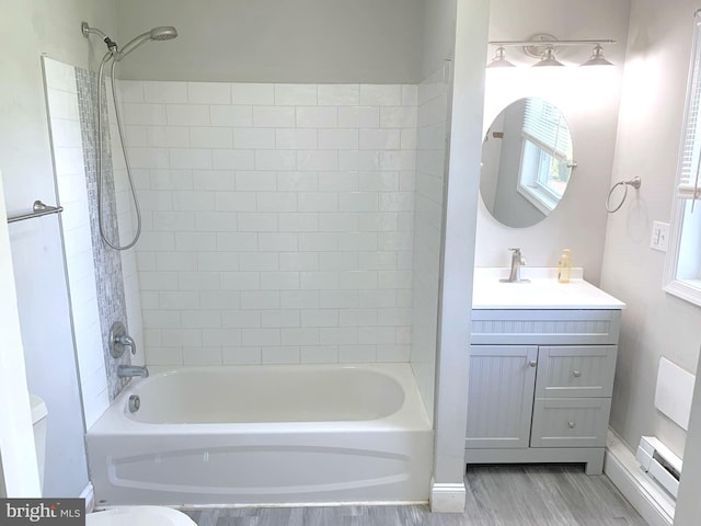 full bathroom featuring vanity, toilet, tiled shower / bath combo, and hardwood / wood-style flooring