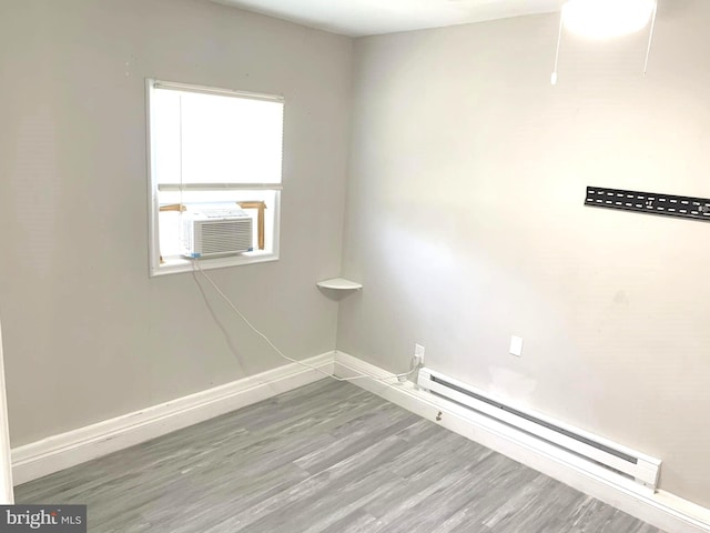 laundry area featuring cooling unit, hardwood / wood-style floors, and a baseboard radiator