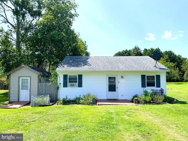 view of front of home with a storage unit, cooling unit, and a front yard