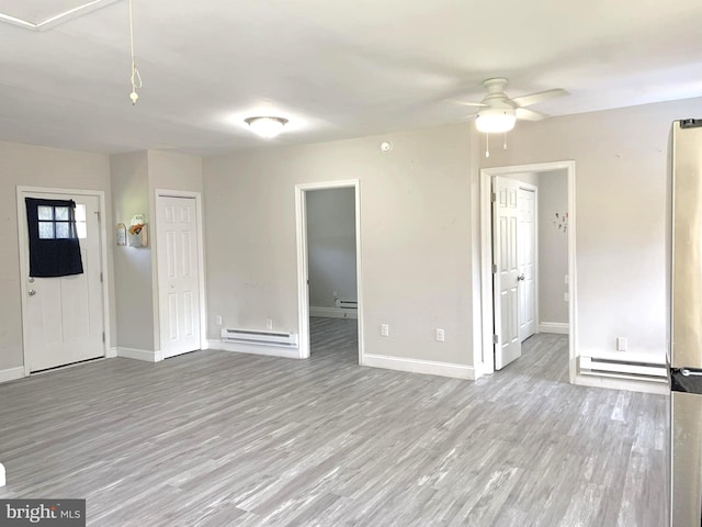 unfurnished room featuring ceiling fan, baseboard heating, and light hardwood / wood-style flooring