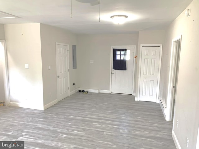 clothes washing area featuring wood-type flooring and electric panel