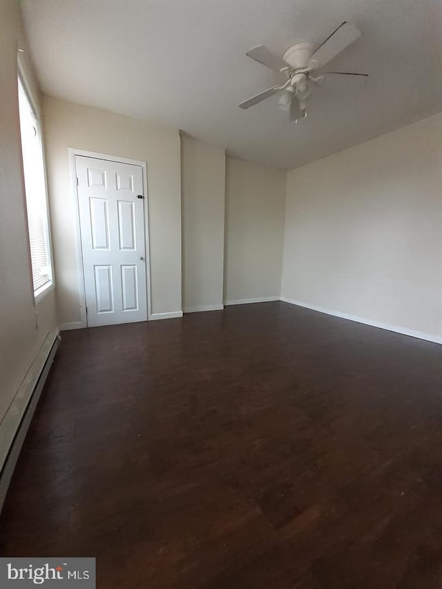 spare room featuring ceiling fan, dark hardwood / wood-style flooring, and a baseboard radiator