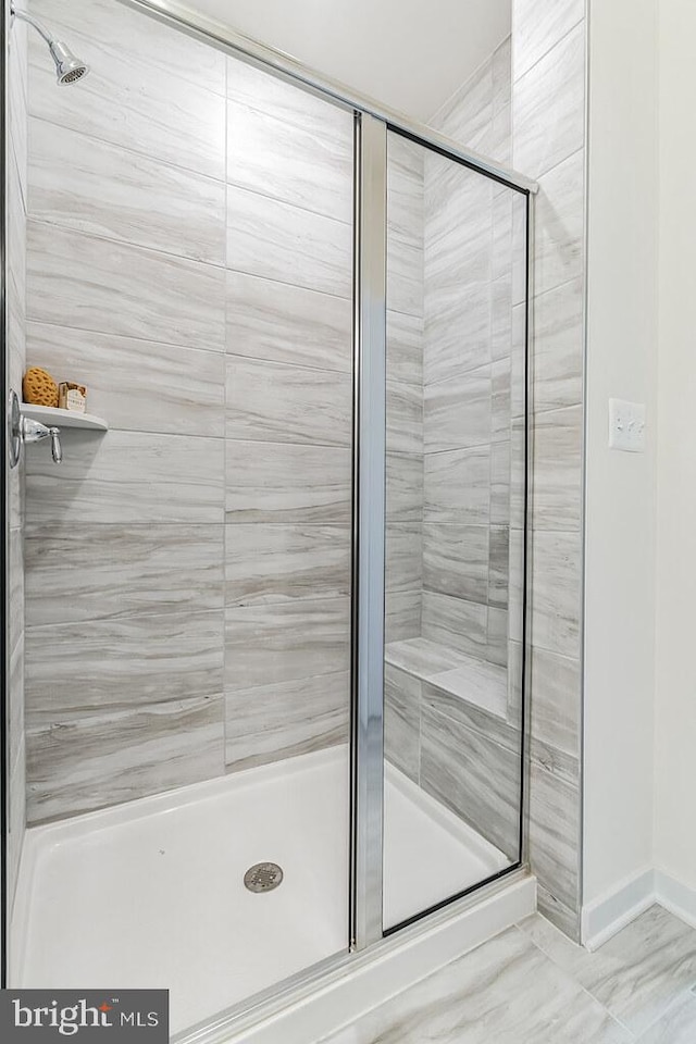 bathroom with a stall shower and baseboards