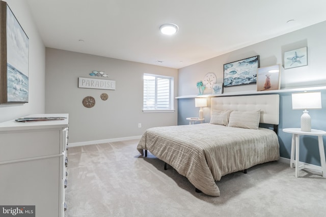 bedroom with light carpet and baseboards