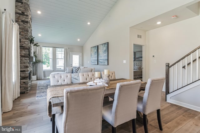 dining space featuring visible vents, stairs, light wood-type flooring, recessed lighting, and high vaulted ceiling