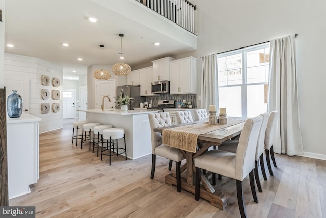 dining room with light wood-style flooring and recessed lighting