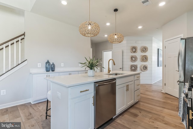 kitchen with visible vents, light countertops, light wood-type flooring, stainless steel dishwasher, and a sink