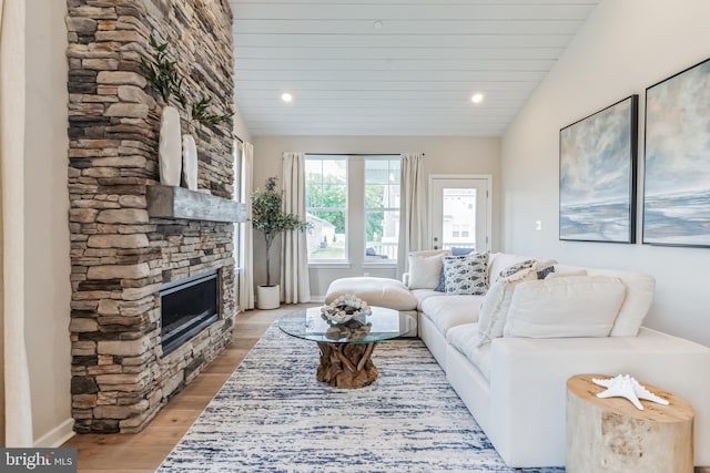 living area with recessed lighting, lofted ceiling, a fireplace, and light wood finished floors