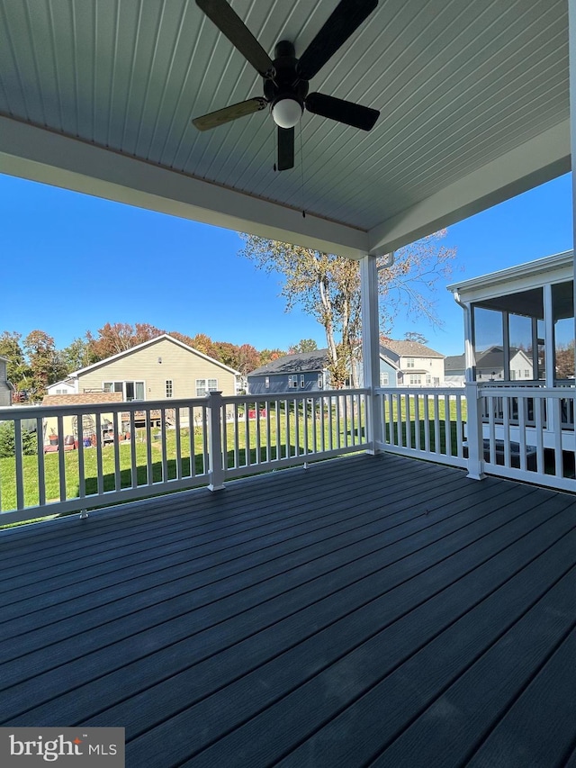 wooden deck featuring a residential view, a ceiling fan, and a yard