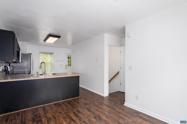 kitchen with sink, range, kitchen peninsula, and dark hardwood / wood-style floors