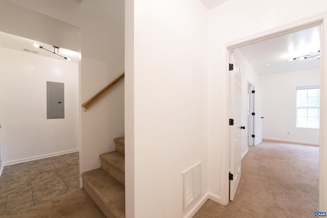 staircase featuring electric panel and tile patterned floors