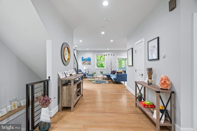 hall with light wood-style floors, baseboards, and recessed lighting