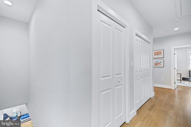 corridor featuring attic access, recessed lighting, baseboards, and light wood finished floors