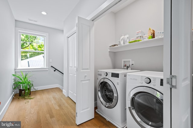 laundry room featuring laundry area, separate washer and dryer, visible vents, baseboards, and light wood-style floors