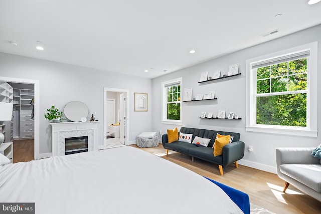 bedroom with baseboards, a spacious closet, wood finished floors, and recessed lighting