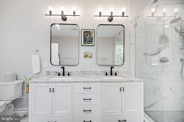 bathroom with a sink, a shower stall, toilet, and double vanity