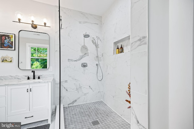 full bathroom with a tile shower and vanity