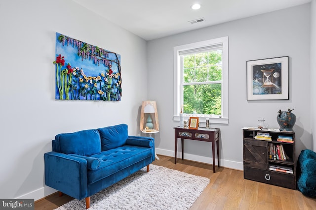 living area with light wood-style floors, recessed lighting, visible vents, and baseboards