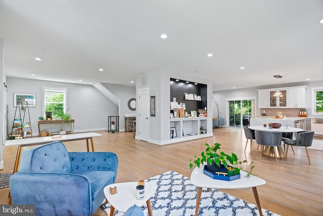 living room featuring plenty of natural light, light wood-type flooring, baseboards, and recessed lighting