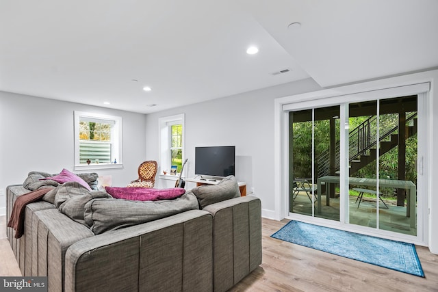 living area with light wood-type flooring, visible vents, baseboards, and recessed lighting