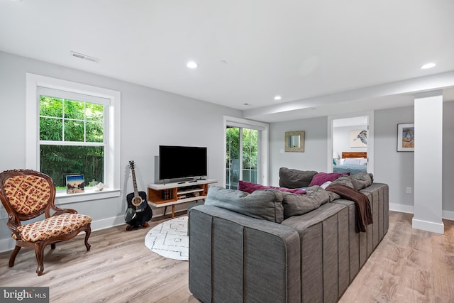 living room with recessed lighting, a healthy amount of sunlight, visible vents, and light wood finished floors