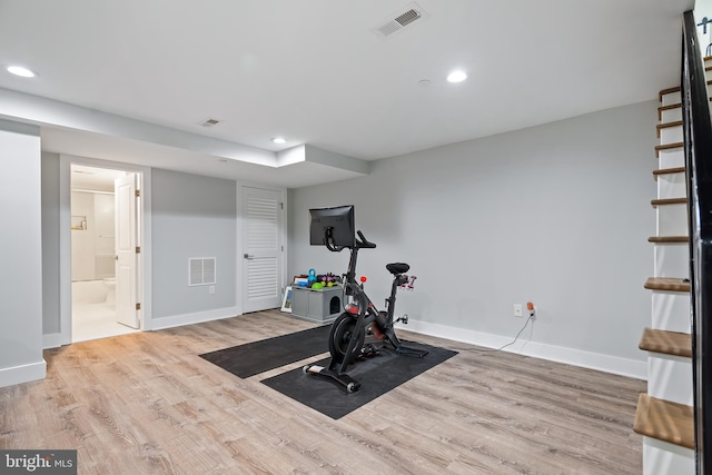 workout area with visible vents, light wood-style flooring, and baseboards