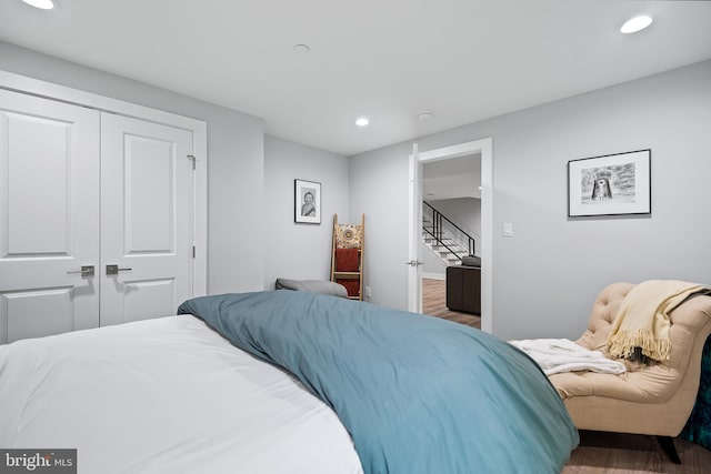 bedroom with recessed lighting, a closet, and wood finished floors