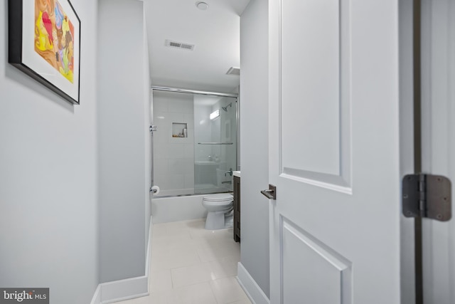 full bathroom with shower / bath combination with glass door, visible vents, toilet, baseboards, and tile patterned floors