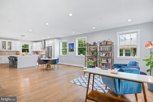 interior space with recessed lighting, a sink, light wood-style flooring, and baseboards