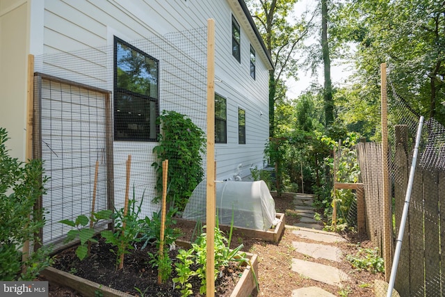 view of property exterior featuring a vegetable garden and fence