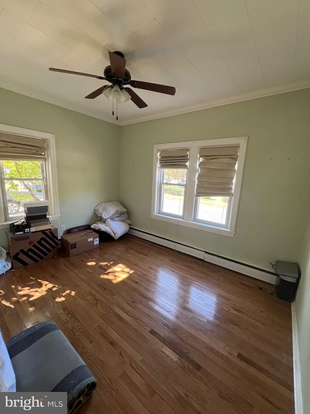 unfurnished bedroom with multiple windows, ornamental molding, baseboard heating, and dark wood finished floors