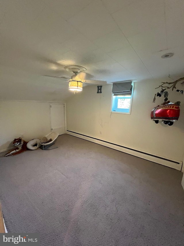 empty room featuring a baseboard heating unit, carpet, and ceiling fan