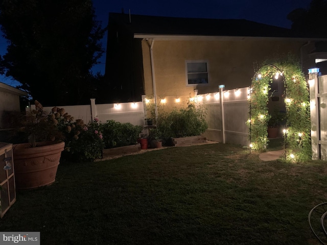 yard at twilight featuring fence