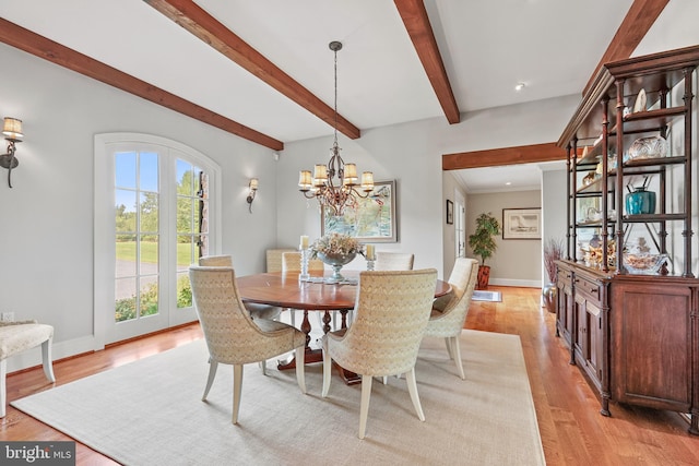 dining space with beam ceiling, light wood-type flooring, and a chandelier