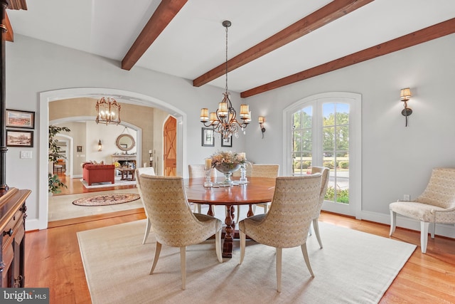 dining area with a chandelier, light hardwood / wood-style floors, and beam ceiling