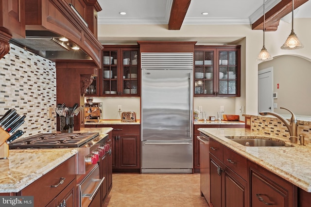 kitchen featuring backsplash, light stone counters, stainless steel appliances, sink, and premium range hood