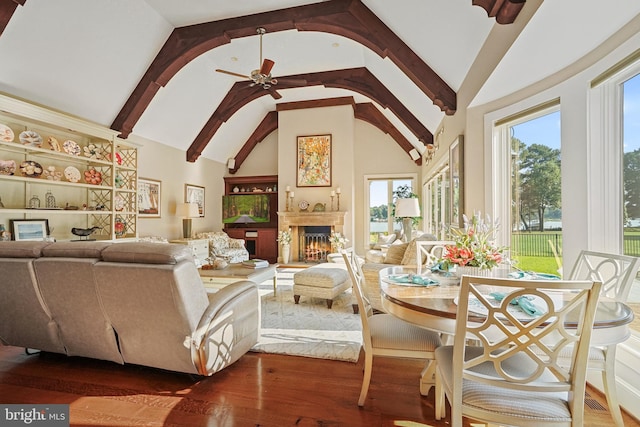 living room featuring beamed ceiling, wood-type flooring, high vaulted ceiling, and ceiling fan