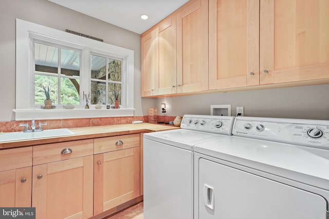 laundry area with sink, cabinets, and washing machine and dryer