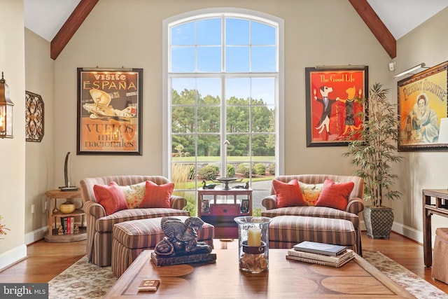 sitting room with a healthy amount of sunlight, beamed ceiling, and hardwood / wood-style flooring