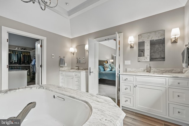 bathroom featuring wood-type flooring, a bathing tub, and vanity