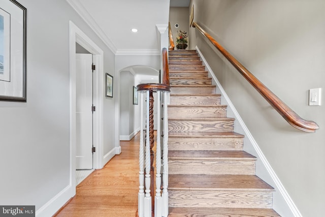 stairs featuring ornamental molding and wood-type flooring