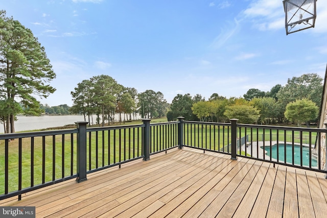 deck with a water view and a yard