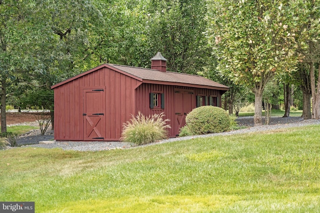 view of outbuilding featuring a yard