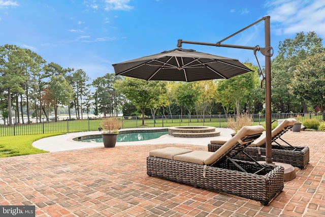 view of patio / terrace with a swimming pool with hot tub and an outdoor fire pit