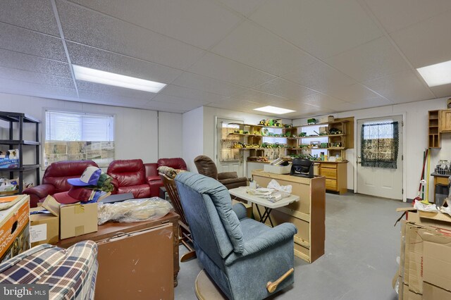 interior space with concrete floors and a paneled ceiling