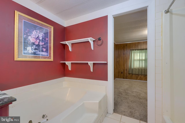 bathroom featuring a tub to relax in, a textured ceiling, and tile patterned flooring